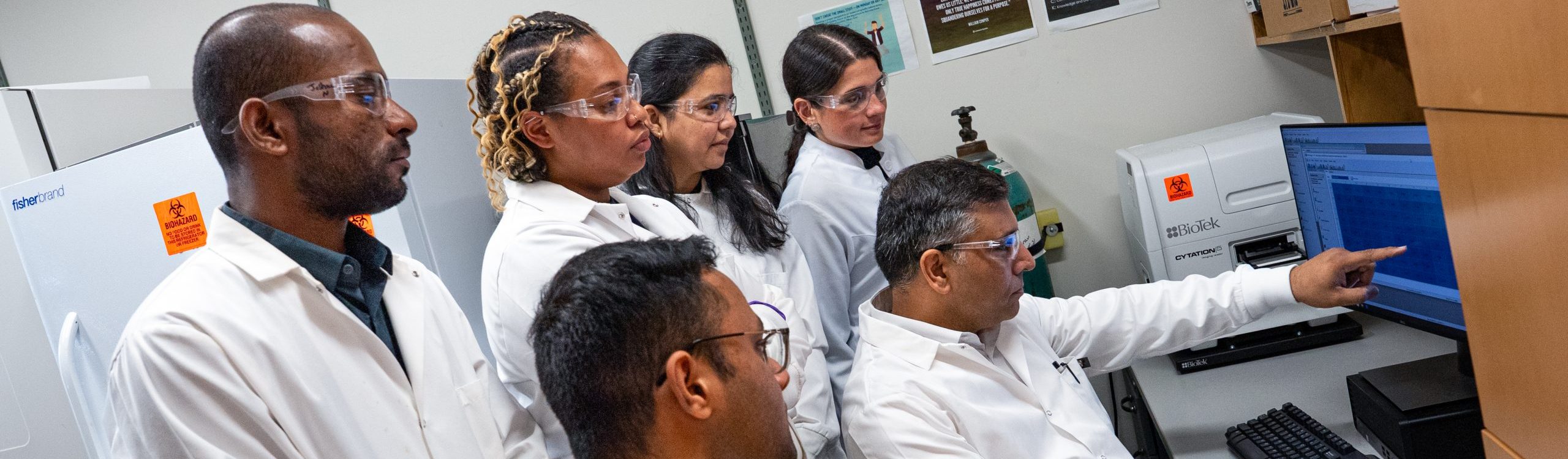 Members of the Upadhyay Lab looking at data on a computer screen
