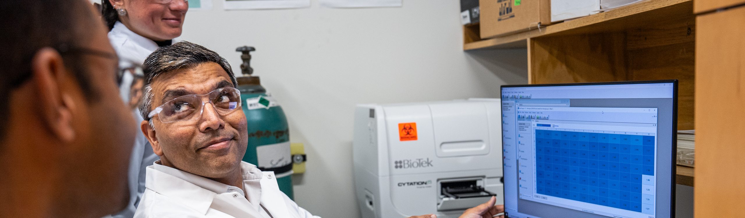 Abhinav Upadhyay showing computer data to his lab group 